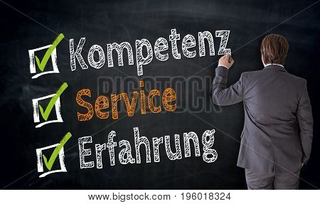 Businessman Writes Kompetenz, Service, Erfahrung (in German Competence, Service, Experience) On Blac