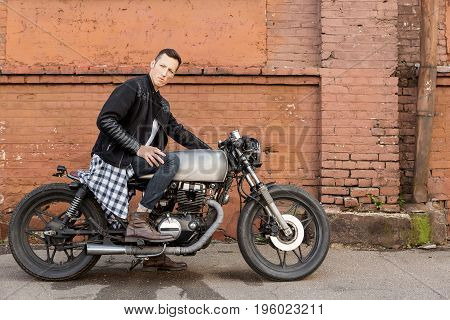 Brutal Man Sit On Cafe Racer Custom Motorbike.