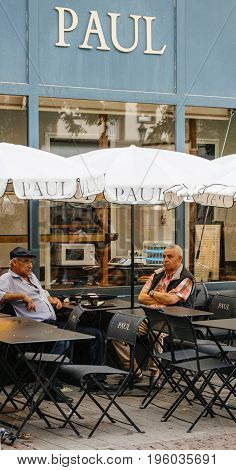 STRASBOURG FRANCE - JUL 12 2017: Paul Boulangerie Et Patisserie cafe with open air terrace on French street and seniors having drinking a cofee. Paul is a French chain of bakery/cafe restaurants established in 1889 in the city of Croix in Northern France