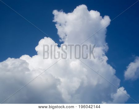 White puffy cumulus clouds in blue sky