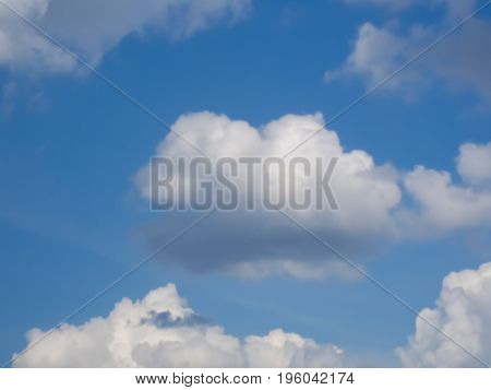White puffy cumulus clouds in blue sky