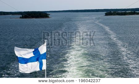 Finnish flag waving over the wake in baltic sea