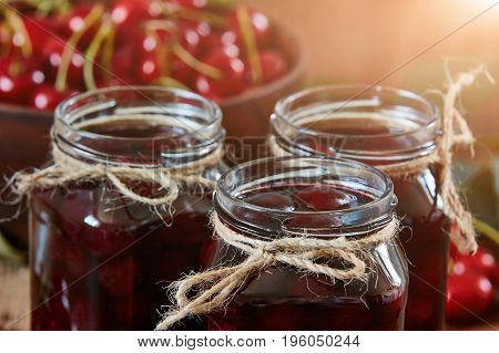 Cherry jam on wooden ground with fresh cherries