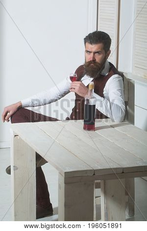 Hipster Drinking Red Wine With Bottle On Wooden Table