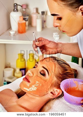 Collagen face mask . Facial skin treatment. Woman receiving cosmetic procedure in beauty salon. Bottle with moisturizing cream on background. Mask of honey, moisturizing the skin.