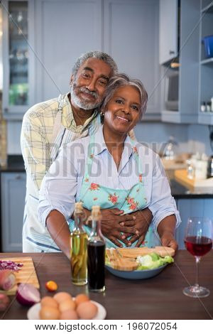 Portrait of Smiling senior couple preparing food in kitchen