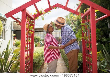 Side view of senior couple talking while standing in yard