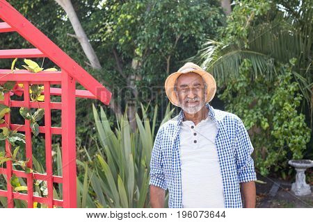 Portrait of senior man standing by metallic structure in yard