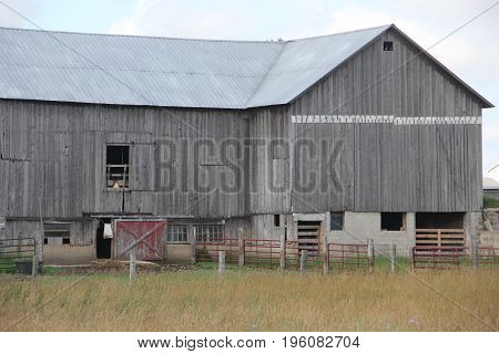 A barn with a fence for lifestock