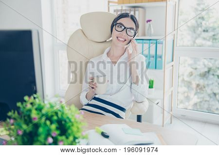 Smiling Young Gorgeous Asian Girl Secretary  Is Drinking Tea At The Break In Office And Talk On The