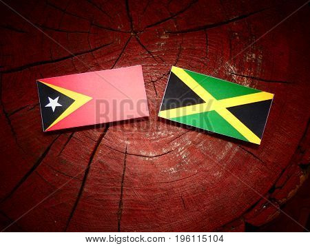 East Timorese Flag With Jamaican Flag On A Tree Stump Isolated