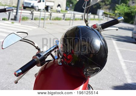 Helmet of a motorcyclist leaning over a motorcycle