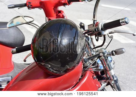 Helmet of a motorcyclist leaning over a motorcycle