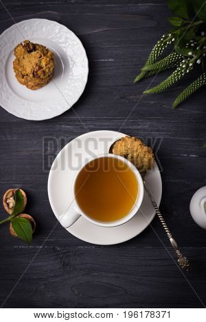 Herbal tea and homemade oatmeal nut cookies on a wooden background. Top view
