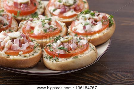 Mini pizza on ready-made buns with tomatoes and sausage