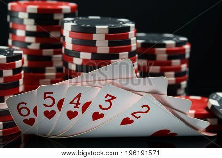 Straight flush against a black background behind a big bet on winning
