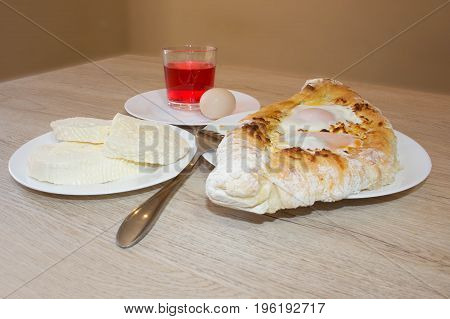 Khachapuri raditional Georgian cheese-filled bread Ajarian style. Adjarian khachapuri with eggs on the table