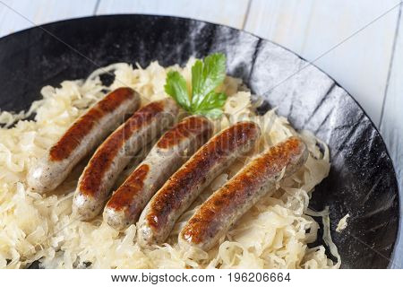 nuremberg bratwurst on cabbage in a pan