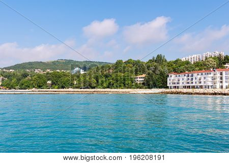 Seascape with azure water and green hills on shoreview on black sea coast with buildings and houses in balchik city Bulgaria.