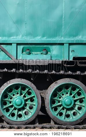 Side View Of The Vehicle On A Caterpillar Track With Black Tracks And Green Wheels And A Side Metal