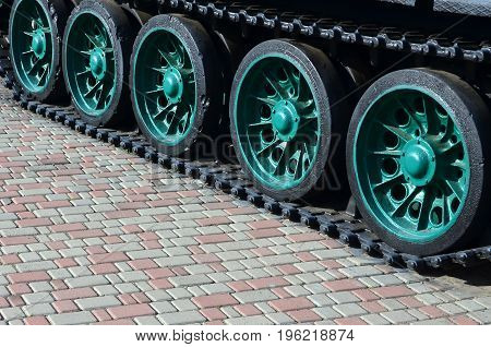 A Military Vehicle On Caterpillar Tracks Stands On A Square Of Paving Stones. Photo Of Green Caterpi