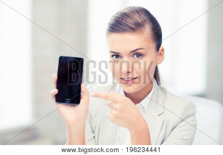 picture of smiling businesswoman with smartphone in office