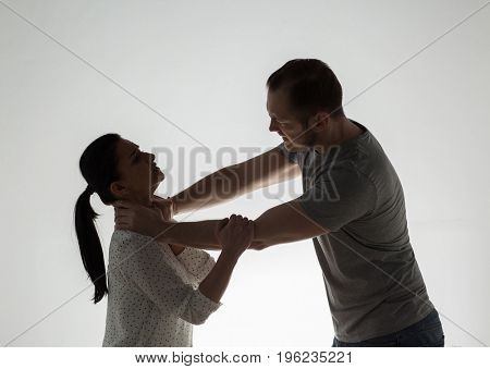 domestic violence, people and abuse concept - couple having fight and man choking woman