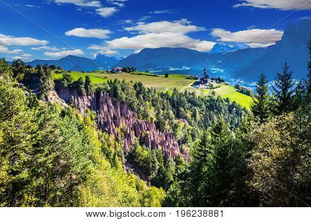 Renon's earth pillars at sunrise. Small mountain village in the Italian Tirol. Journey to the magic country. The concept of ecological tourism