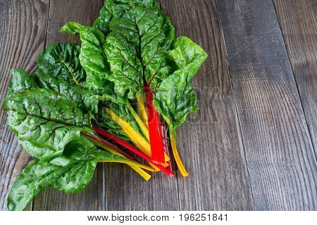 The colorful stems of Chard on dark wooden table, from above