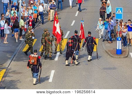 Zurich, Switzerland - 1 August, 2016: participants of the parade devoted to the Swiss National Day passing along Uraniastrasse street. The Swiss National Day is the national holiday of Switzerland, celebrated on 1 August.