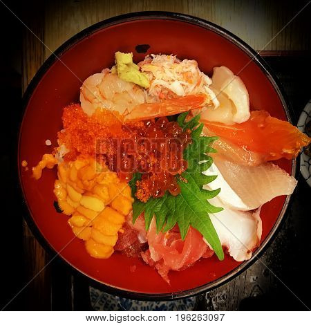Delicious mix of raw fish straight from the market in Japan. Fish includes salmon tuna fish roe eggs shrimp and crab with wasabi. With a vignette.