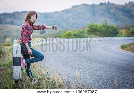 Tourist Hitchhiking Woman Standing On The Road In The Mountains.