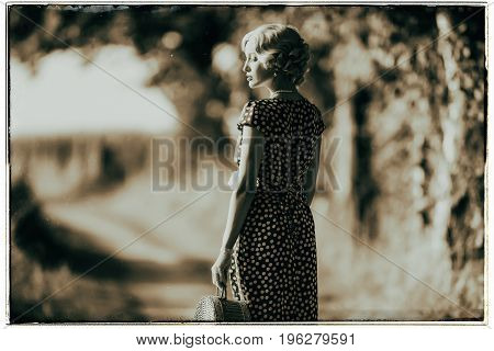 Classic Black And White Photo Of 1930S Fashion Woman Standing With Handbag On Rural Pathway.