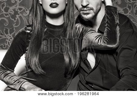 Sexy woman with red lips embrace young rich man black and white seduction