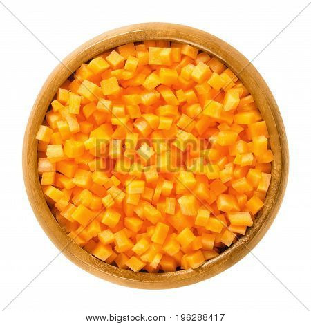Carrot cubes in wooden bowl. Fresh cut crisp pieces of Daucus carota, a root vegetable with orange color. Edible taproot. Isolated macro food photo close up from above on white background.