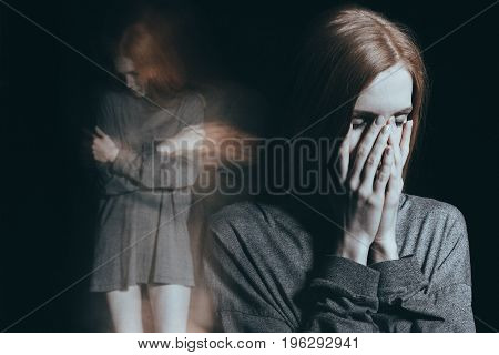 Innocent girl feeling overwhelming loneliness and embraces herself in a mental illness concept