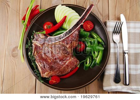 santoreggia: arrosto di manzo di ricambio rib sul piatto scuro con pepe Timo posate e pomodoro sul tavolo di legno