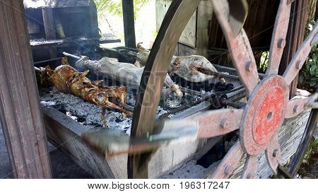 Baking lamb on a spit. Wheel rotates the barbecue.