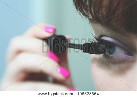 Make Up Vanity 3: self portrait of a woman applying mascara, shallow depth of field put attention on her eye