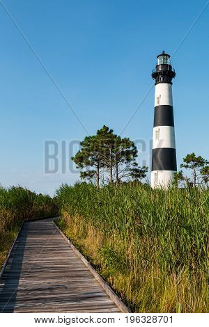 Wooden boardwalk through marshland leading to the historic Bodie Island lighthouse on the Outer Banks of North Carolina.