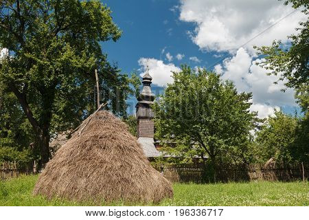 Old wooden Lemk church against a bright blue sky with clouds. Culture of Ukraine