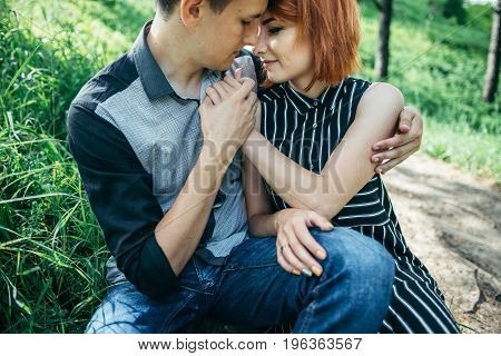 portrait of beautiful young pair in a park sitting on the ground