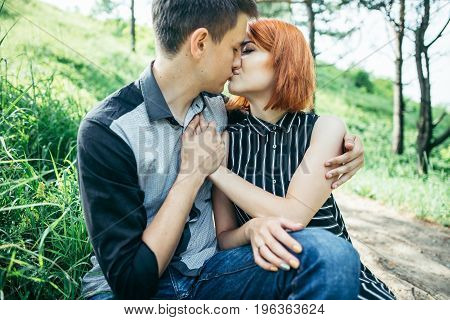 portrait of beautiful young pair in a park sitting on the ground