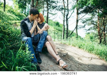 portrait of beautiful young pair in a park sitting on the ground
