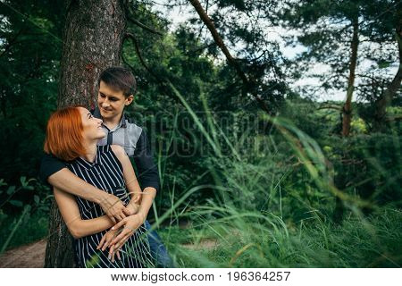 Love couple kissing under a tree, readhead girlfriend