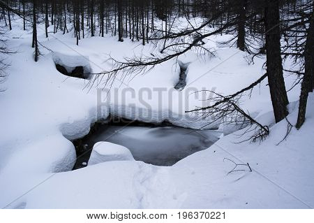 frozen creek during winter in alpe devero