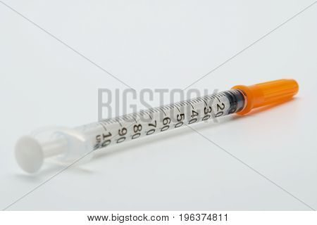 Insulin syringe with orange cover isolated on white background