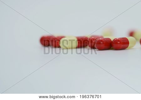 Red, yellow antibiotic capsule pills on white background