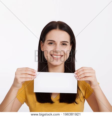 Your text here. Pretty young excited woman holding empty blank board. Studio portrait on white background. Mockup for design