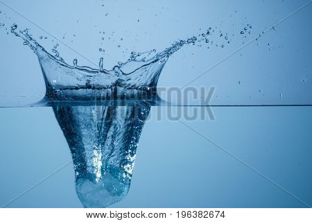 Piece of ice falling into water at high speed and causing a splash